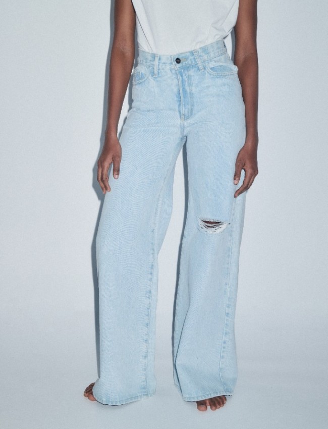 Mid blue jean ψηλόμεση παντελόνα, σε φαρδιά γραμμή, με ταμπά γαζιά, τετράγωνες τσέπες πίσω, φθορές στο ένα πόδι και κλείσιμο με κουμπί και κρυφό φερμουάρ Combos Knitwear  