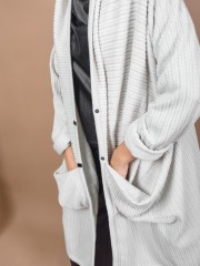 Εκρού oversized μακριά σχεδιαστική ζακέτα με ανάγλυφη υφή, ιδιαίτερες τσέπες με σούρες μπροστά, ρεγκλάν μανικοκόλληση και ρεβέρ στα μανίκια Kramma