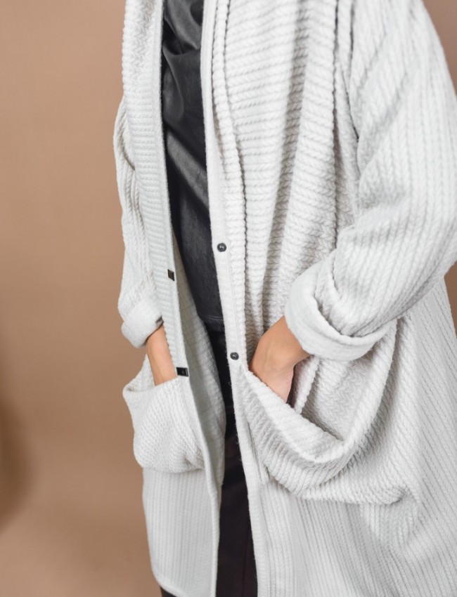 Εκρού oversized μακριά σχεδιαστική ζακέτα με ανάγλυφη υφή, ιδιαίτερες τσέπες με σούρες μπροστά, ρεγκλάν μανικοκόλληση και ρεβέρ στα μανίκια Kramma