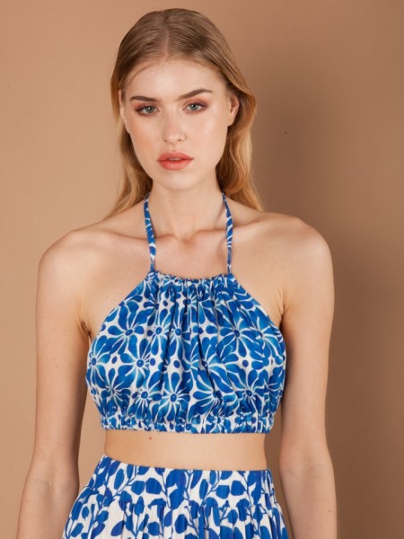 Εμπριμέ μπλε αμάνικη cropped Luce Blue μπλούζα με παρτούς ώμους, λάστιχο κατω απο το μπούστο και δέσιμο στο λαιμό Mallory the Label