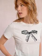 Λευκή κοντομάνικη βαμβακερή μπλούζα, σε ίσια γραμμή, με ανοιχτή στρογγυλή λαιμόκοψη και τύπωμα μαύρο φιόγκο Molly Bracken 