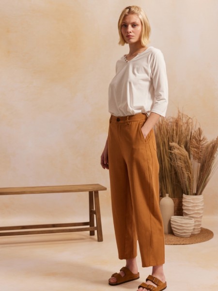 Μπεζ ψηλόμεσο AMINA1 παντελόνι, σε slouchy fit γραμμή, τετράγωνες τσέπες πίσω και κλείσιμο με κουμπί και κρυφό φερμουάρ μπροστά Namaste 