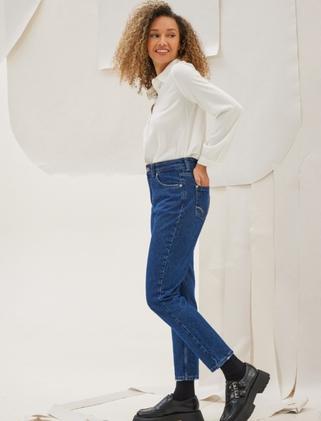 Blue jean ψηλόμεσο παντελόνι KAMBOS σε σταθερό ΄ύφασμα, ίσια γραμμή, χωρίς ξεβάμματα και μικρά ξέφτια στο επάνω μέρος στην τετράγωνη τσέπη πίσω Namaste