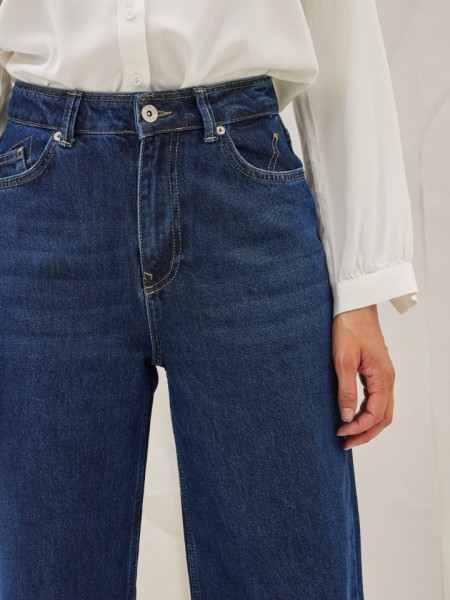 Blue jean ψηλόμεση cropped παντελόνα ZIGOS σε ίσια γραμμή, χωρίς ξεβάμματα, μπροστινές στρογγυλεμένες τσέπες και κεντήματα στις τετράγωνες τσέπες πίσω Namaste