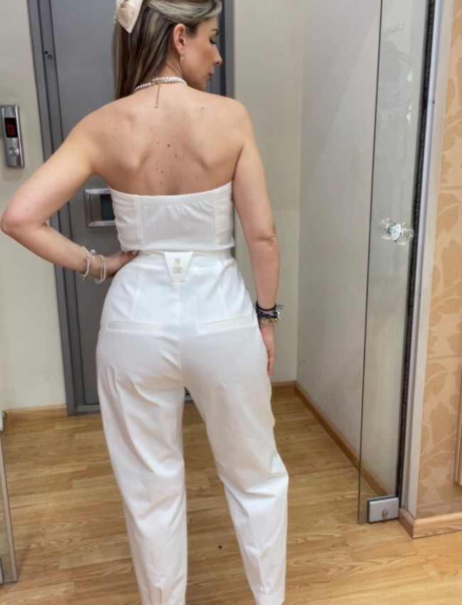 Λευκή strapless ολόσωμη φόρμα σε χαλαρή γραμμή, με πλαινές τσέπες, κλείσιμο με χρυσό φερμουάρ μπροστά και αποσπώμενη υφασμάτινη ζώνη We Coss