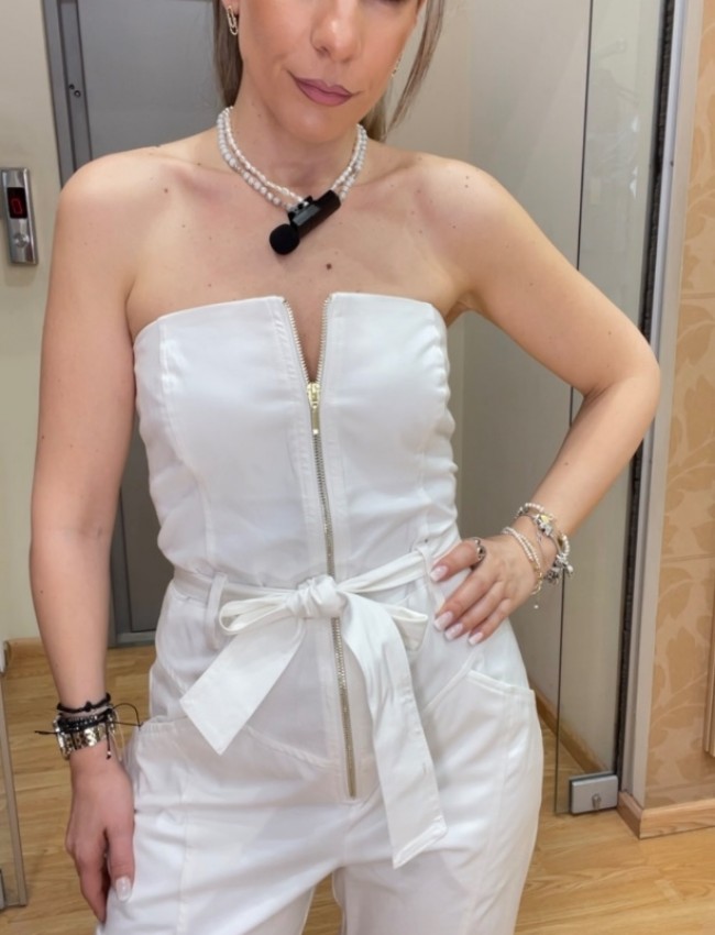 Λευκή strapless ολόσωμη φόρμα σε χαλαρή γραμμή, με πλαινές τσέπες, κλείσιμο με χρυσό φερμουάρ μπροστά και αποσπώμενη υφασμάτινη ζώνη We Coss