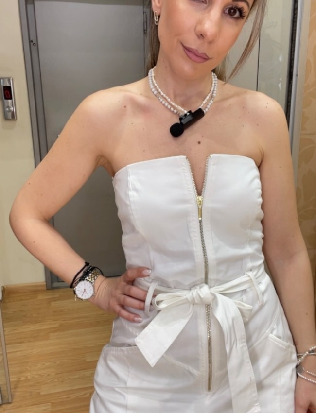 Λευκή strapless ολόσωμη φόρμα σε χαλαρή γραμμή, με πλαινές τσέπες, κλείσιμο με χρυσό φερμουάρ μπροστά και αποσπώμενη υφασμάτινη ζώνη We Coss