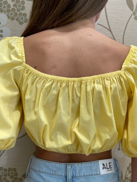 Κίτρινη  κοντομάνικη βαμβακερή cropped μπλούζα με έξω ώμους, λάστιχο στα τελειώματα και δέσιμο με κόμπο στην πλάτη We coss