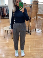 Ριγέ γκρι ψηλόμεσο παντελόνι office style σε ίσια γραμμή με μπροστινές πιέτες, πλαϊνές τσέπες, ρεβέρ στο ποδόγυρο και κλείσιμο με φερμουάρ και κουμπί μπροστά we coss