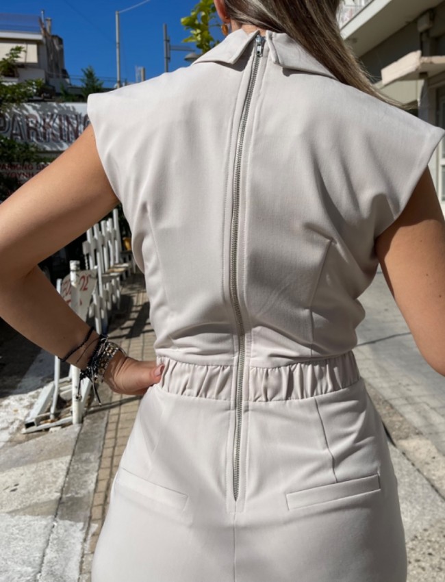 Βανίλια αμάνικη ολόσωμη φόρμα με κρουαζέ πάνω μέρος, πέτο γιακά, μπροστινές πιέτες, πλαϊνές τσέπες, λάστιχο πίσω στην μέση και κλείσιμο με φερμουάρ στην πλάτη We Coss 