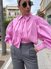 Ροζ μακρυμάνικο ποπλίνα cropped πουκάμισο με πολλές πιέτες-σούρες, έντονα φαρδιά μανίκια, κλείσιμο με ιδιαίτερο κουμπί στην λαιμόκοψη και στις μανσέτες We coss