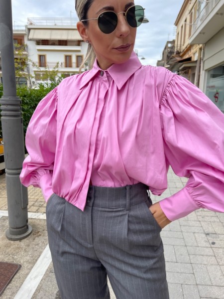 Ροζ μακρυμάνικο ποπλίνα cropped πουκάμισο με πολλές πιέτες-σούρες, έντονα φαρδιά μανίκια, κλείσιμο με ιδιαίτερο κουμπί στην λαιμόκοψη και στις μανσέτες We coss
