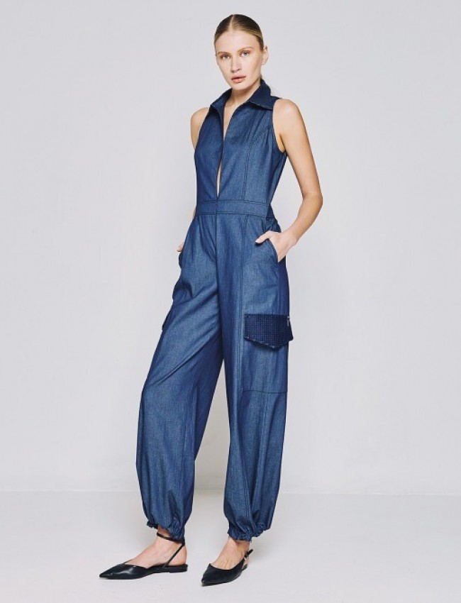 Blue jean tencel αμάνικη ολόσωμη φόρμα, τύπου cargo, με πέτο γιακά, καπακωτές τσέπες πίσω, λεπτομέρειες με κεντημένες μπλε παγιέτες, κλείσιμο με φερμουάρ μπροστά και ρυθμιζόμενο κορδόνι στο τελείωμα στον ποδόγυρο Access   