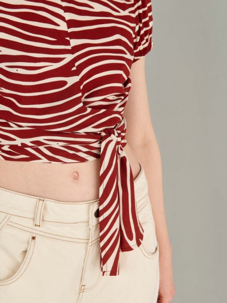 Animal printed εκάι κοντομάνικη μπλούζα με ανοιχτή στρογγυλή λαιμόκοψη, πιέτες στους ώμους, λάστιχο στο τελείωμα στο μανίκι, κρουαζέ δέσιμο στο τελείωμα και ανοιχτή πλάτη Ale