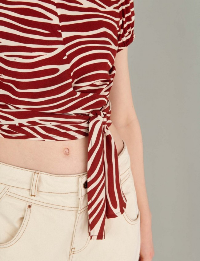 Animal printed εκάι κοντομάνικη μπλούζα με ανοιχτή στρογγυλή λαιμόκοψη, πιέτες στους ώμους, λάστιχο στο τελείωμα στο μανίκι, κρουαζέ δέσιμο στο τελείωμα και ανοιχτή πλάτη Ale