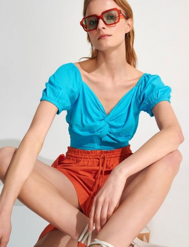 Γαλάζιο κοντομάνικο cropped top με κόμπο στο στήθος, λάστιχα στα τελειώματα και μη αποσπώμενη ζώνη Ale 