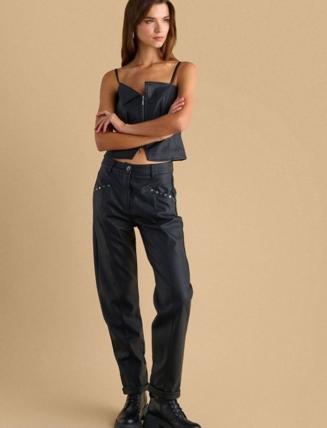 Μαύρο ψηλόμεσο faux-leather παντελόνι σε ίσια γραμμή, μικρό ρεβέρ στον ποδόγυρο, διακοσμητικές ραφές, μπροστινές πλαγιές τσέπες με διακοσμητικά τρουκς και κλείσιμο κρυφό φερμουάρ και κουμπί μπροστά Attrattivo 