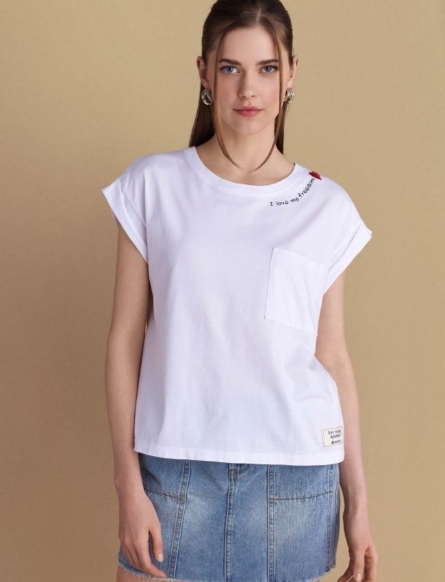 Λευκό βαμβακερό κοντομάνικο t-shirt, με κλειστή στρογγυλή λαιμόκοψη, σε τετράγωνη γραμμή, με τετράγωνη τσέπη μπροστά και κεντημένο λογότυπο "I love my freedom"Attrattivo  