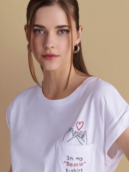 Λευκό βαμβακερό κοντομάνικο t-shirt, με ανοιχτή στρογγυλή λαιμόκοψη, με τετράγωνη τσέπη μπροστά και κεντημένο λογότυπο "In my "Bestie" t-shirt" Attrattivo 