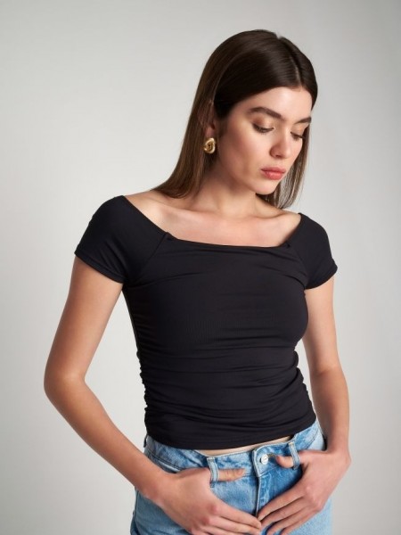Μαύρη κοντομάνικη ελαστική cropped μπλούζα σε "βούτυρο" ποιότητα, με ανοιχτή χαμόγελο λαιμόκοψη και μικρές σούρες στο πλάι Attrattivo