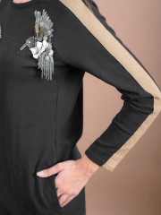 Μαύρη μακρυμάνικη μακριά πλεκτή μπλούζα με στρογγυλή λαιμόκοψη, μπροστινές στρογγυλεμένες τσέπες, χρυσή lurex φάσα στα μανίκια και σχεδιαστικό κέντημα "πουλί" Badoo