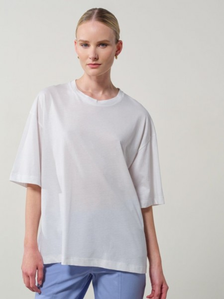 Λευκή βαμβακερή oversized κοντομάνικη μπλούζα, με ρεγκλάν μανικοκόλληση, κλειστή στρογγυλή λαιμόκοψη και τύπωμα με λουλούδια στην πλάτη Enzzo 