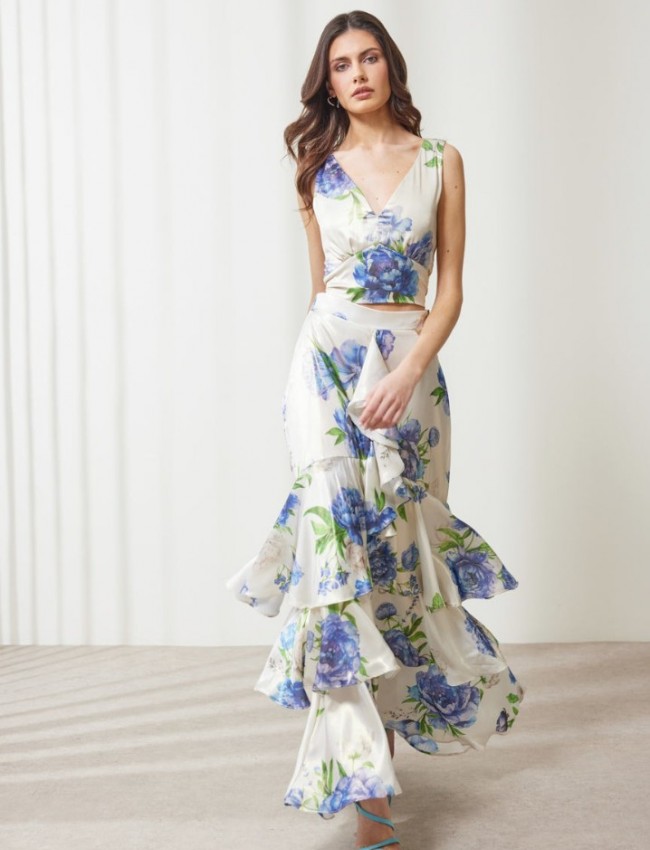 Floral printed μπλε μεταλλιζέ maxi Aubrey φούστα, με βολάν σε επίπεδα, κάθετο βολάν με μπροστινό σκίσιμο, λάστιχο πίσω στην μέση και κλείσιμο με κρυφό φερμουάρ στο πλάι Enzzo  