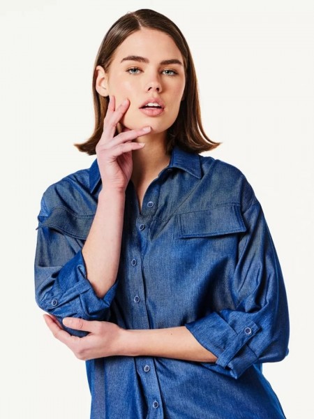 Blue jean πουκάμισο με 3/4 μανίκι σε χαλαρή γραμμή, με μπροστινές καπακωτές τσέπες και ίσιο τελείωμα Forel