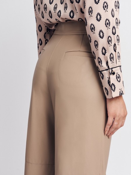 Βανίλια ψηλόμεση faux-leather παντελόνα, σε ίσια γραμμή, τσέπες με πατιλέτες πίσω, πλαϊνές κοφτές τσέπες μπροστά και κλείσιμο με δυο επενδυμένα κουμπιά και κρυφό φερμουάρ μπροστά Forel