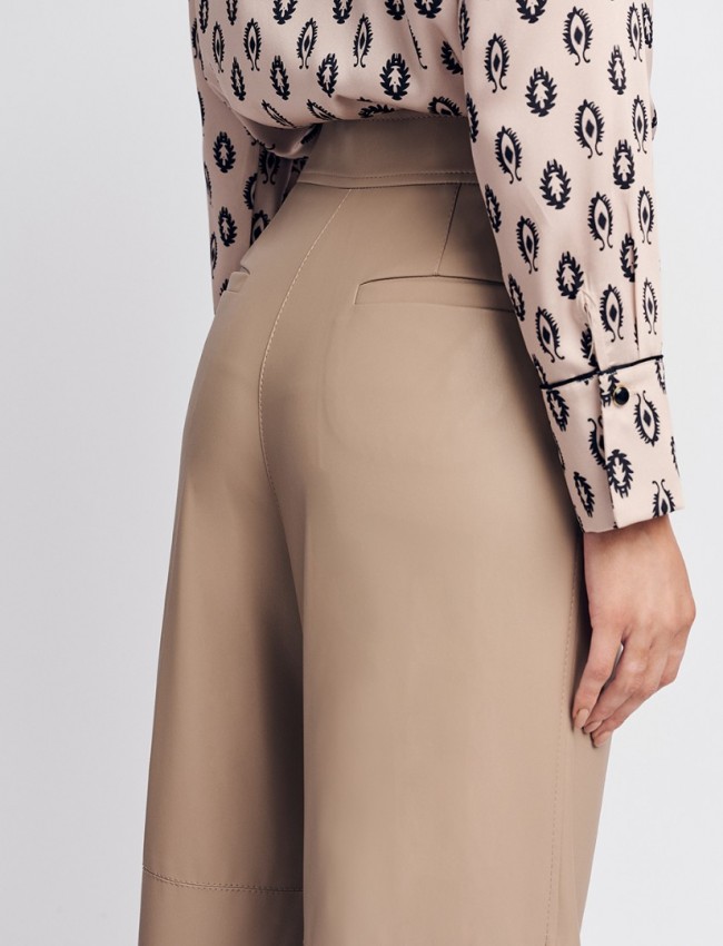 Βανίλια ψηλόμεση faux-leather παντελόνα, σε ίσια γραμμή, τσέπες με πατιλέτες πίσω, πλαϊνές κοφτές τσέπες μπροστά και κλείσιμο με δυο επενδυμένα κουμπιά και κρυφό φερμουάρ μπροστά Forel