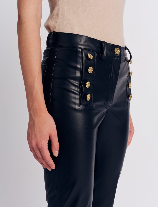 Μαύρο faux-leather ψηλόμεσο ελαστικό παντελόνι καμπάνα σε εφαρμοστή γραμμή, με διπλή σειρά χρυσά κουμπιά, τετράγωνες τσέπες πίσω και κλείσιμο με φερμουάρ και κουμπί Forel 