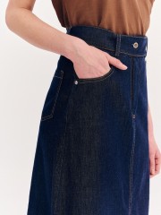 Blue jean ψηλόμεση midi φούστα, σε Α γραμμή, με ταμπά διακοσμητικά γαζιά, τετράγωνες τσέπες πίσω, κλείσιμο με κουμπί και κρυφό φερμουάρ μπροστά και αποσπώμενη ζώνη Forel 