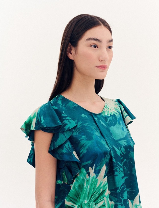 Floral printed πράσινη σατέν κοντομάνικη μπλούζα, σε ίσια γραμμή, με ανοιχτή στρογγυλή λαιμόκοψη και πιέτα μπροστά, βολάν στα μανίκια και στρογγυλεμένο τελείωμα Forel