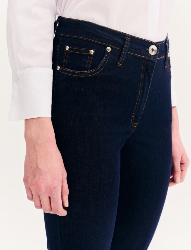 Blue jean ψηλόμεσο ελαστικό παντελόνι καμπάνα, με ταμπά γαζιά, τετράγωνες τσέπες πίσω, και κλείσιμο με κουμπί και κρυφό φερμουάρ μπροστά Forel 
