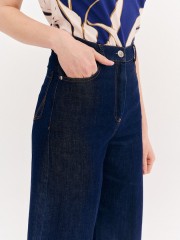 Blue jean ψηλόμεση ελαστική cropped παντελόνα, σε ίσια γραμμή, με ταμπά γαζιά, τετράγωνες τσέπες πίσω και κλείσιμο με κουμπί και κρυφό φερμουάρ μπροστά Forel 