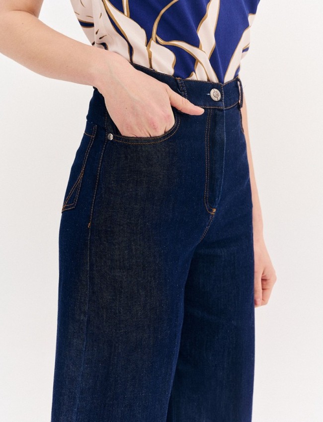 Blue jean ψηλόμεση ελαστική cropped παντελόνα, σε ίσια γραμμή, με ταμπά γαζιά, τετράγωνες τσέπες πίσω και κλείσιμο με κουμπί και κρυφό φερμουάρ μπροστά Forel 