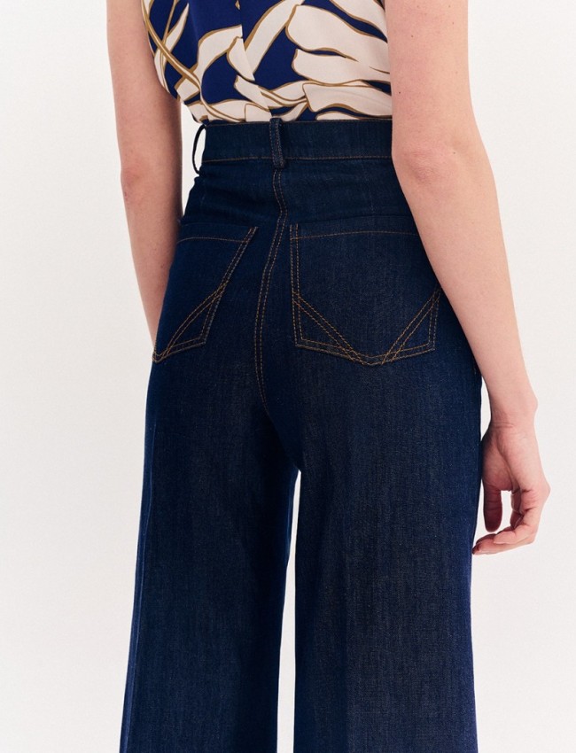 Blue jean ψηλόμεση ελαστική cropped παντελόνα, σε ίσια γραμμή, με ταμπά γαζιά, τετράγωνες τσέπες πίσω και κλείσιμο με κουμπί και κρυφό φερμουάρ μπροστά Forel 