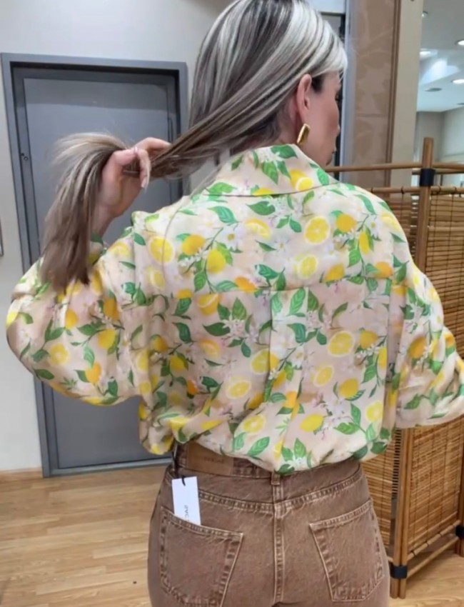 Floral printed κίτρινο πουκάμισο με τύπωμα λεμόνια, σε χαλαρή γραμμή, πλαϊνά ανοίγματα, κουφόπιετα στην πλάτη και δέσιμο με ρυθμιζόμενο κόμπο στο μπροστινό ασύμμετρο τελείωμα innocent