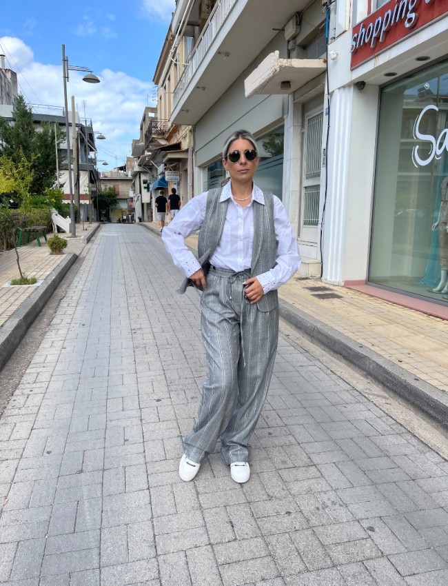 Ριγέ γκρι ψηλόμεση παντελόνα σε ίσια γραμμή με lurex ρίγα στην ύφανση, πλαϊνές τσέπες, μπροστινές πιέτες, λάστιχο στη μέση και ρυθμιζόμενο κορδόνι Innocent 