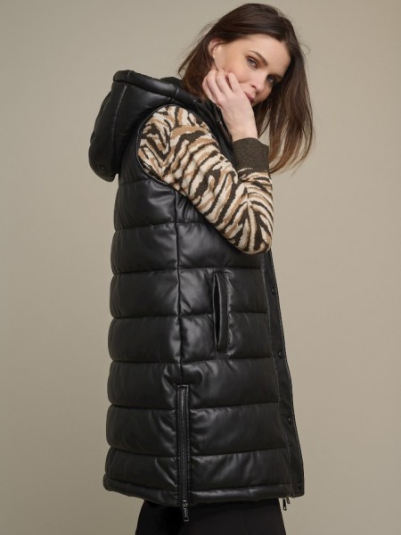 Μαύρο faux-leather μακρύ γιλέκο με αποσπώμενη κουκούλα, οριζόντια διακοσμητικά γαζιά, μπροστινές τσέπες, κλείσιμο με κρυφό φερμουάρ μπροστά και πλαϊνά φερμουάρ στο τελείωμα Rino & Pelle